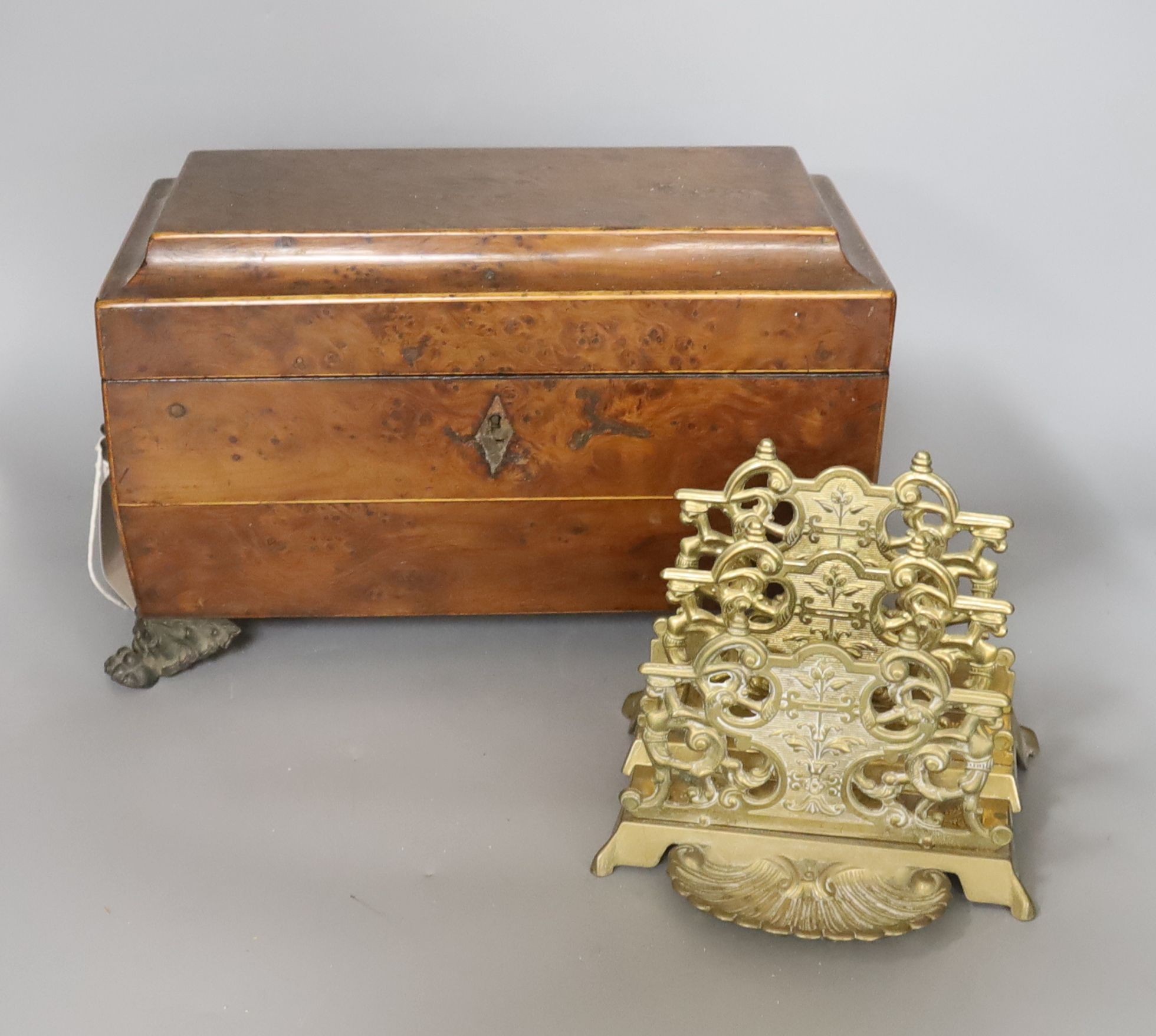 A late Georgian burr yew tea caddy, on gilt metal lion’s paw feet (lacking interior), 31 x 20cm, and a cast brass letter rack (2)